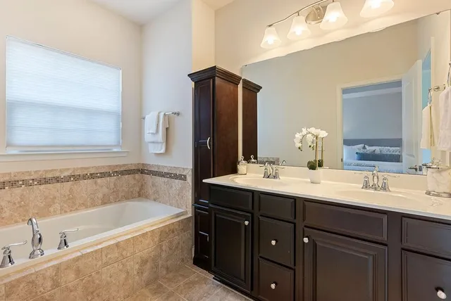 a bathroom with a tub a sink and mirror