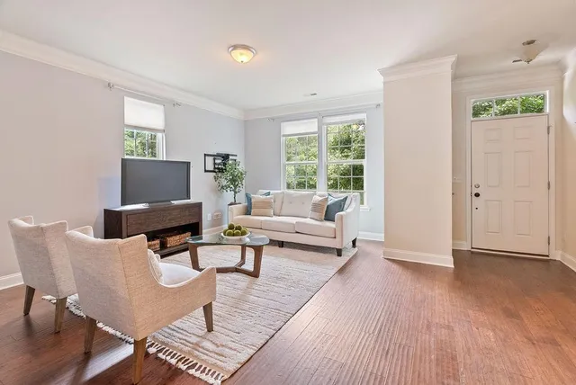 a living room with furniture a rug and a window