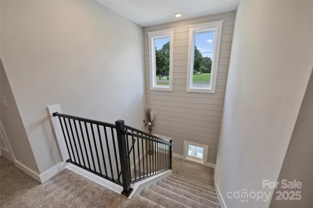 a view of a hallway with wooden floor and stairs