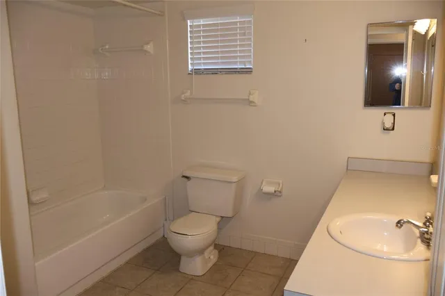a white toilet sitting next to a bathroom sink and tub