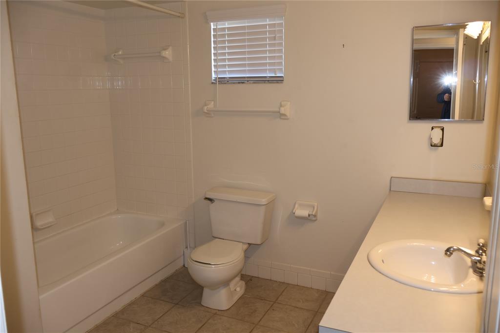 6522 Southwest 60th Court Ocala, FL 34474 - Photo 20 of 23 a white toilet sitting next to a bathroom sink and tub