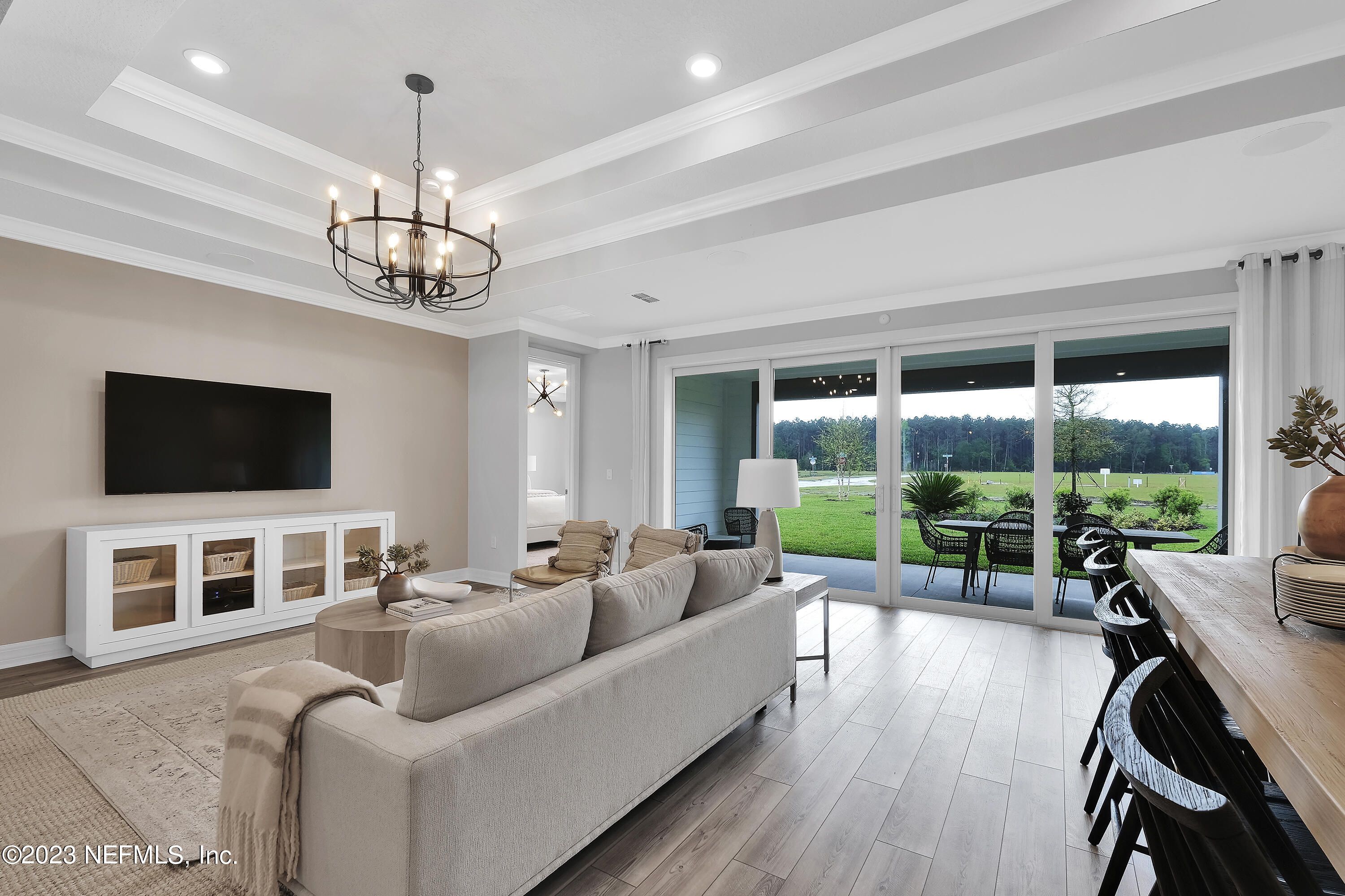 12435 Clapboard Blf Trail Jacksonville, FL 32226 - Photo 14 of 30 a living room with furniture floor to ceiling window hardwood floor and a flat screen tv