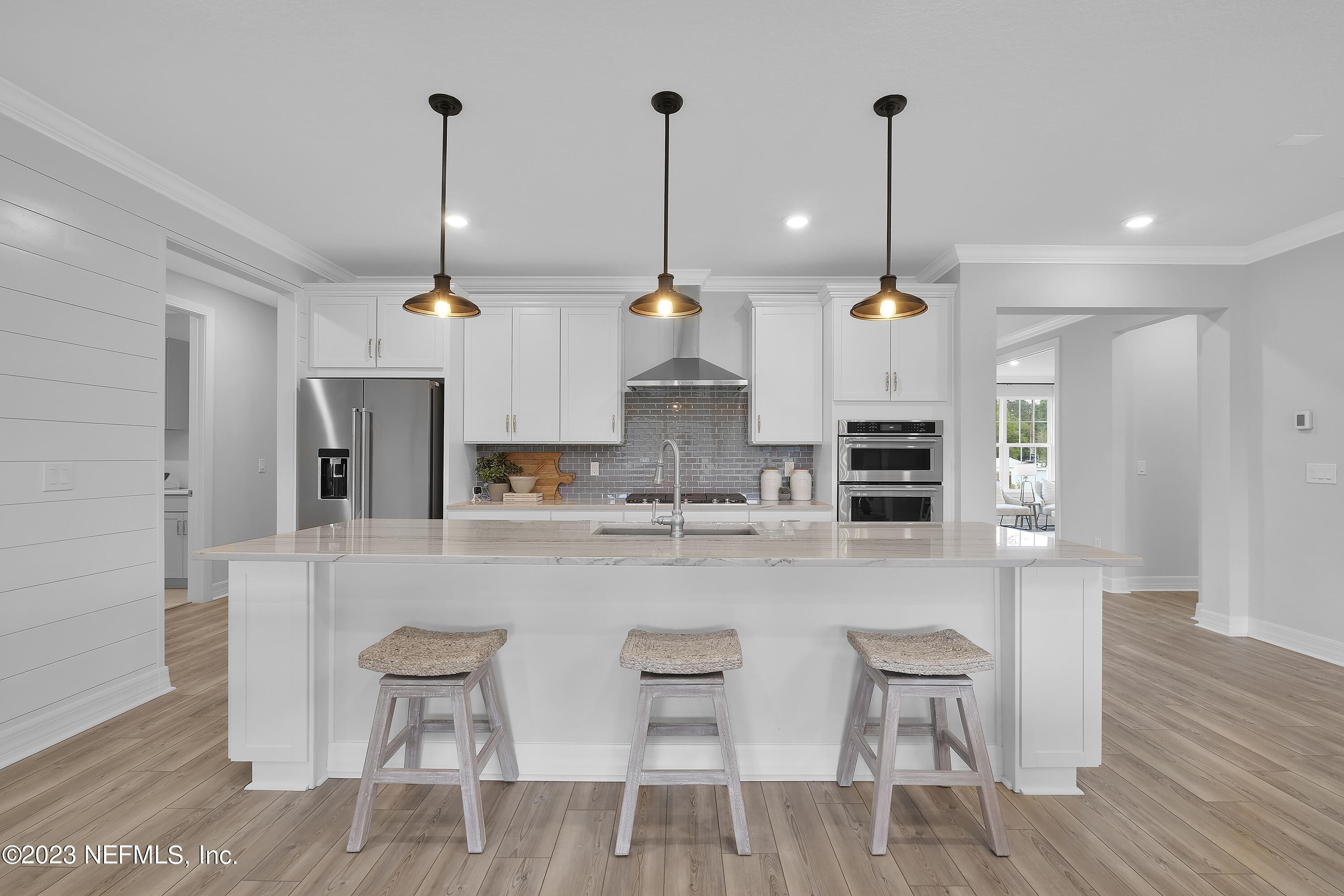 12435 Clapboard Blf Trail Jacksonville, FL 32226 - Photo 10 of 30 a large kitchen with kitchen island a dining table chairs and white cabinets