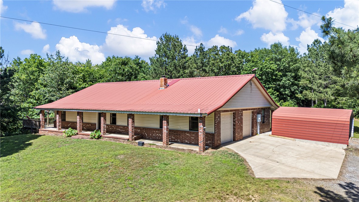 655 Charton Road Morrilton, AR 72110 - Photo 2 of 49 Ranch-style residence featuring a prominent red metal roof, brick veneer siding, and a full-length covered front porch with brick pillars