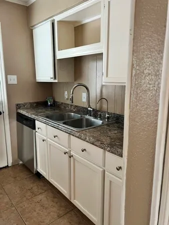 a bathroom with a granite countertop toilet sink and mirror