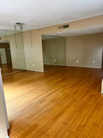 an empty room with wooden floor and fireplace