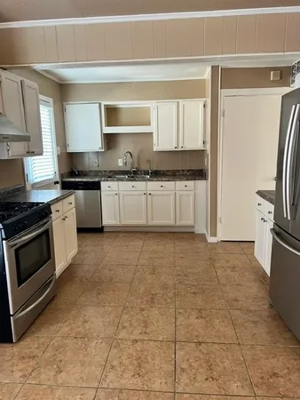 a metallic refrigerator freezer sitting in a kitchen