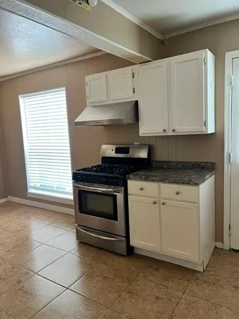 a close view of a sink a mirror and cabinets