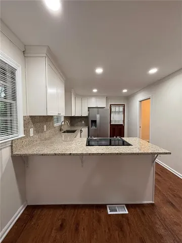 a view of kitchen with stainless steel appliances granite countertop a stove a sink and a refrigerator