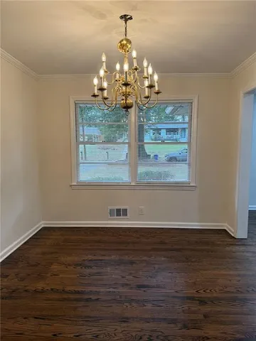 a view of a room with wooden floor chandelier and white walls