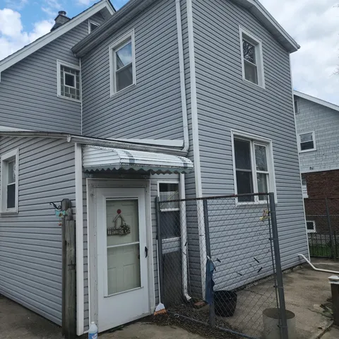 a view of a house with white door and a large tree
