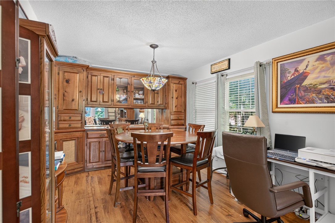 104 Laurel Lane Seneca, SC 29678 - Photo 7 of 36 Hardwood floors and a distinctive chandelier illuminate this inviting dining space, ideal for lively gatherings.