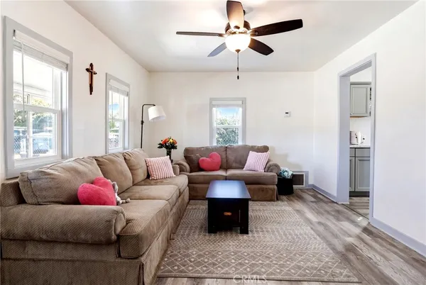 a kitchen with a refrigerator a sink dishwasher a dining table and chairs with wooden floor