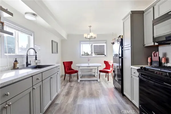 a kitchen with stainless steel appliances granite countertop white cabinets a stove top oven and sink