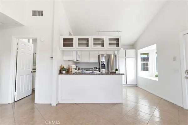 a kitchen with white cabinets and white appliances