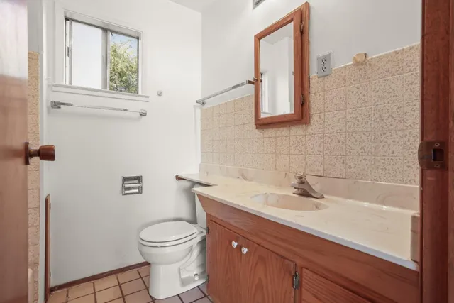 a bathroom with a sink a toilet and a mirror