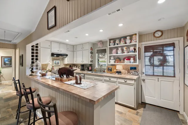 a kitchen with stainless steel appliances kitchen island granite countertop a sink and cabinets