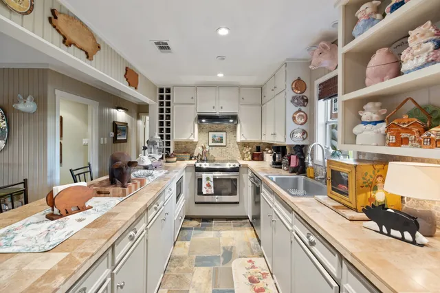 a large kitchen with stainless steel appliances granite countertop a lot of counter space and wooden floor