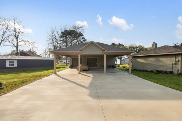 a view of a house with a yard and a large tree