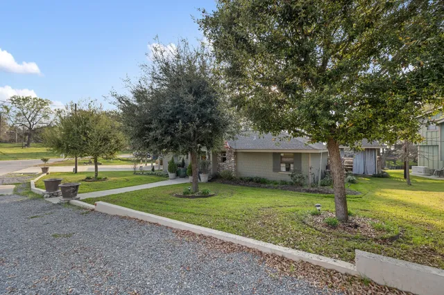 a view of a house with a yard and tree s