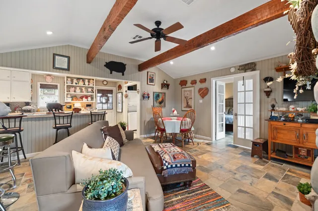 a living room with furniture kitchen view and a large window