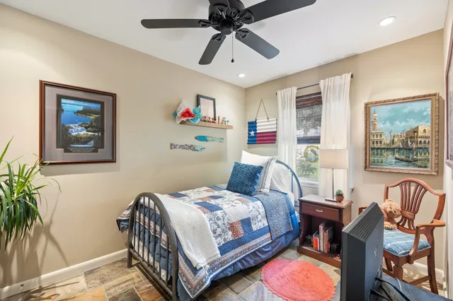 a bedroom with a bed a couch and a potted plant