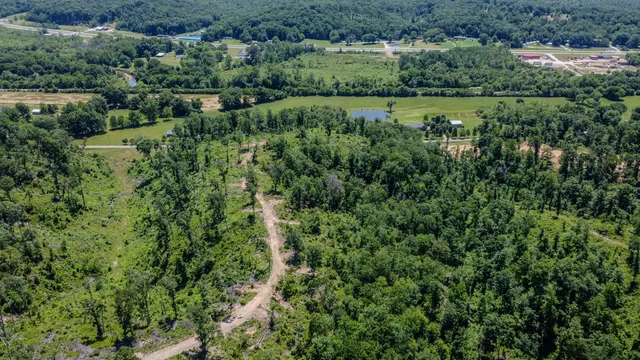 an aerial view of a houses with a lush green hillside