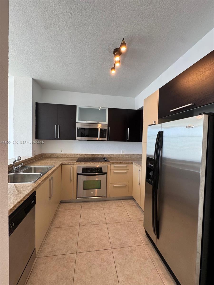 500 Northeast 29th Street, Unit 907 Miami, FL 33137 - Photo 2 of 8 a large kitchen with a stove a refrigerator and a sink