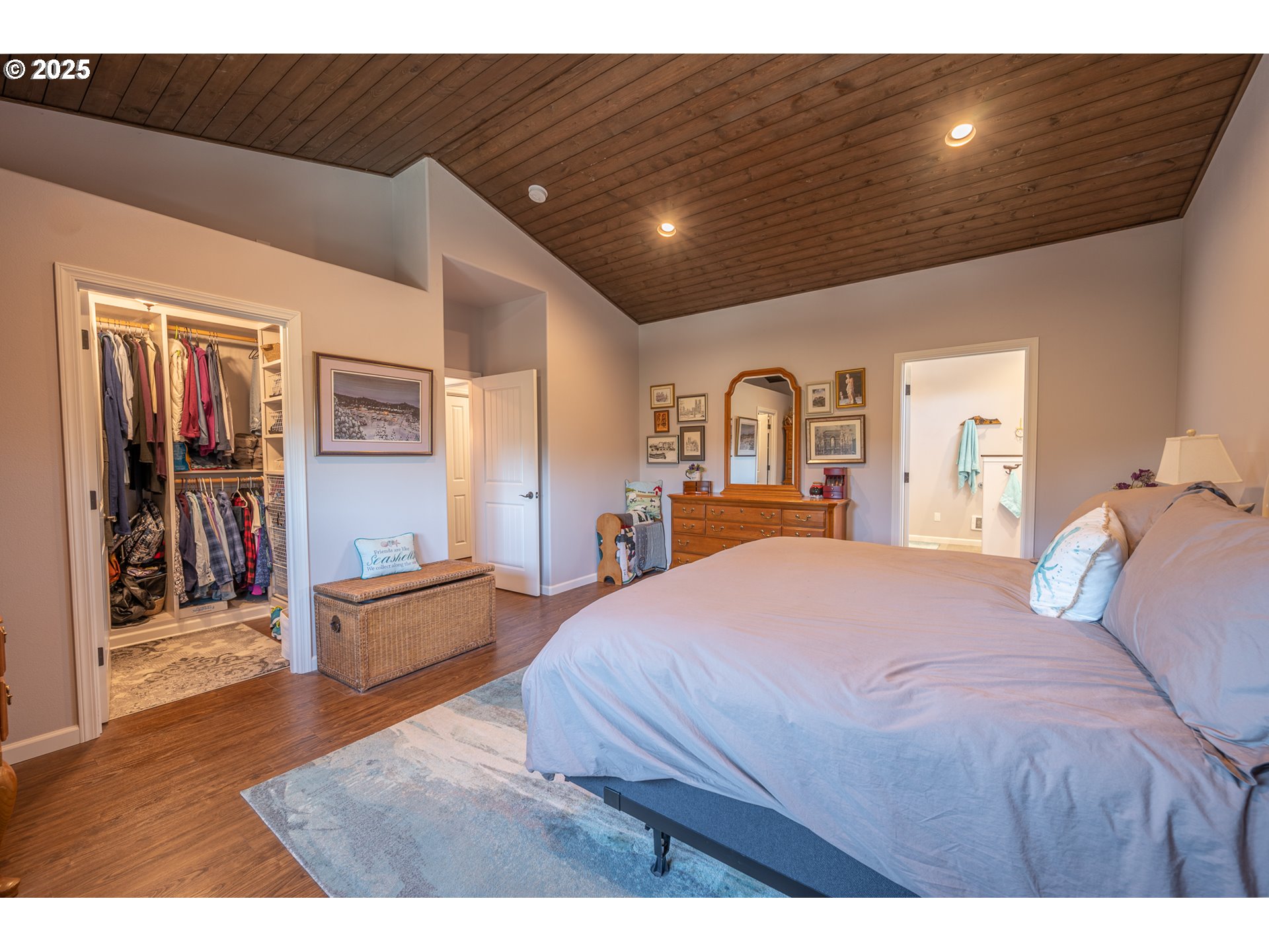 2686 Cedar Loop Bandon, OR 97411 - Photo 24 of 42 a spacious bedroom with a bed and glass walk in closet