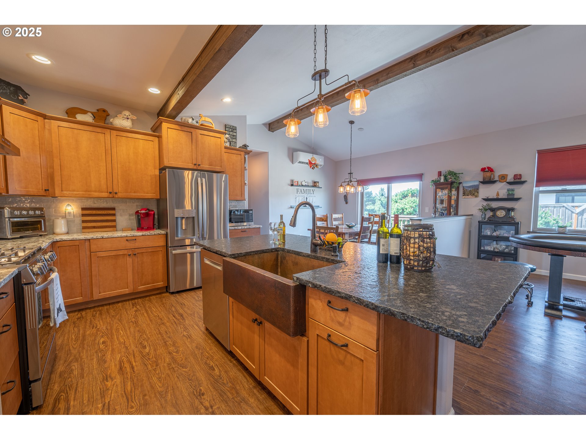2686 Cedar Loop Bandon, OR 97411 - Photo 8 of 42 a kitchen with stainless steel appliances granite countertop a sink dishwasher a refrigerator and a dining table with wooden floor