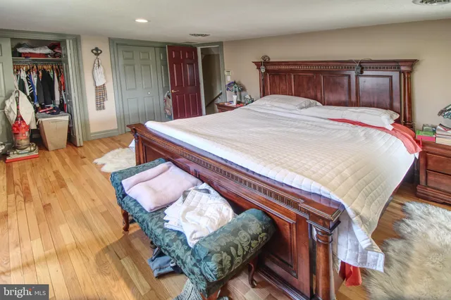 a bedroom with bed and wooden floor