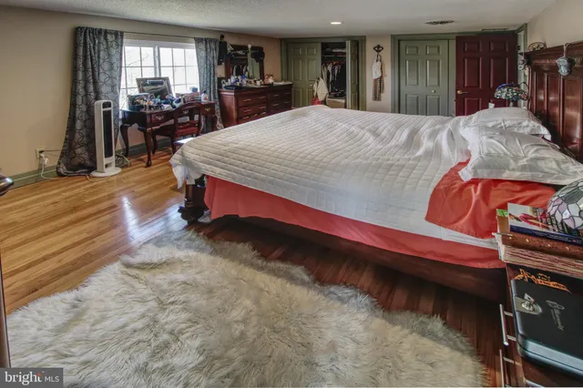 a bed sitting in a spacious bedroom next to a window