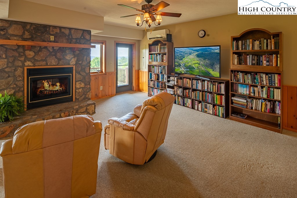 980 Scenic Drive Vilas, NC 28692 - Photo 26 of 42 a living room with furniture a floor to ceiling window and a flat screen tv