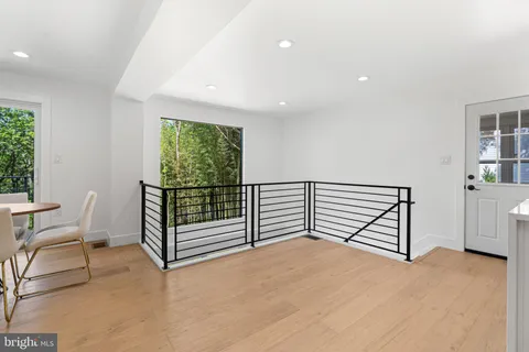 a kitchen with kitchen island granite countertop a stove a refrigerator a oven a sink a dining table and chairs with wooden floor