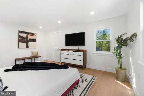 a bedroom with bed and wooden floor