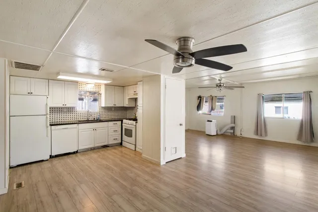 a kitchen with stainless steel appliances kitchen island hardwood floor sink and stove