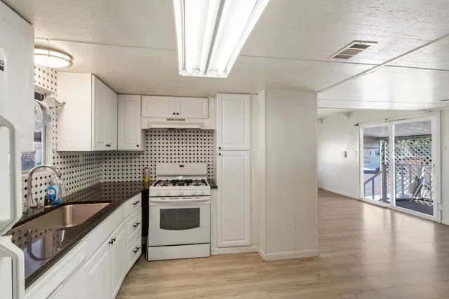 a kitchen with granite countertop a stove and a sink