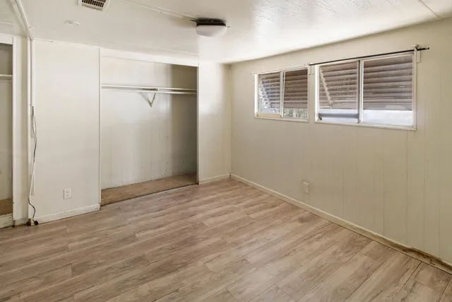 a view of empty room with wooden floor and windows