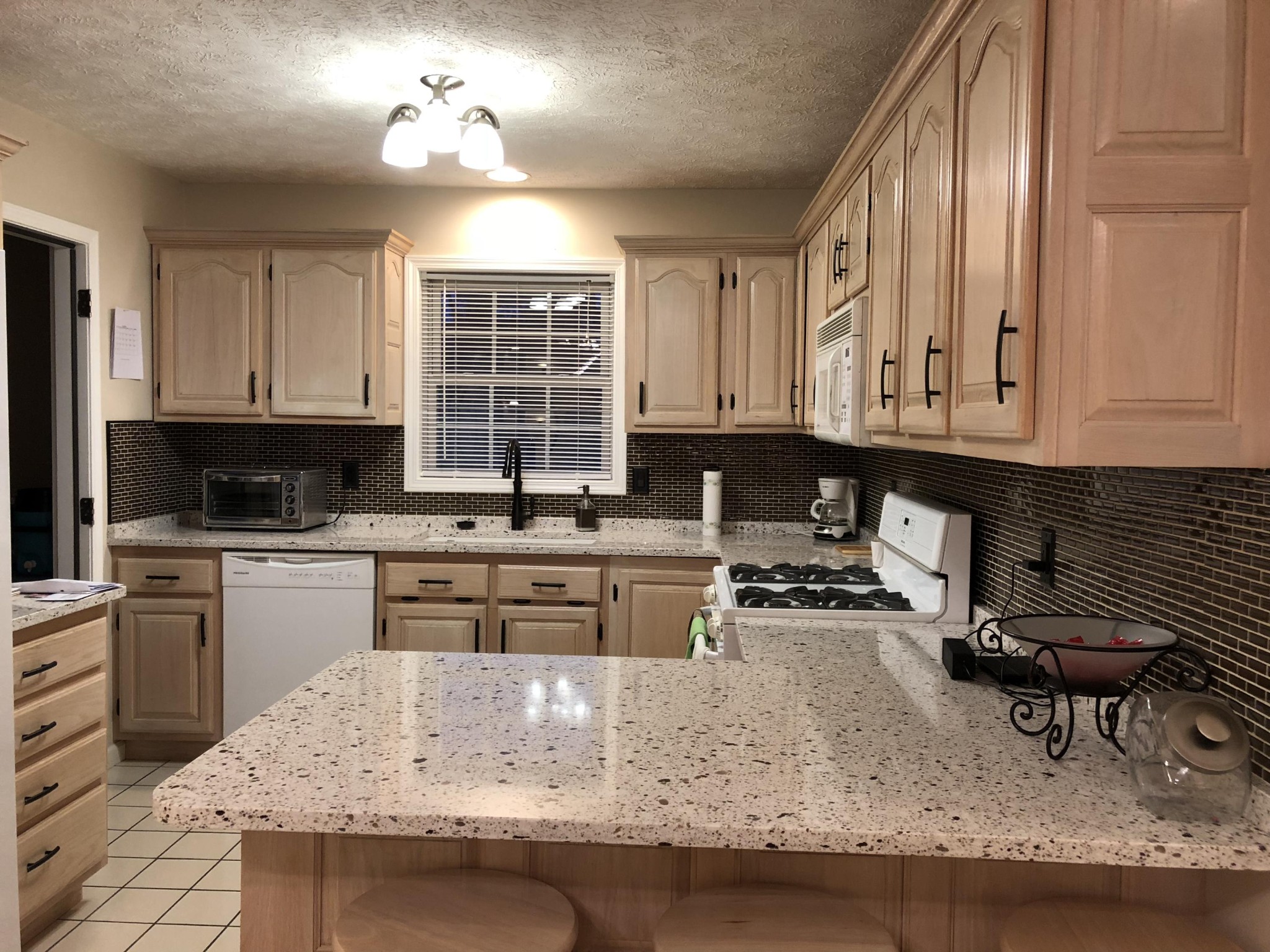 13711 Vonore Road Loudon, TN 37774 - Photo 18 of 34 a kitchen with kitchen island granite countertop a stove a sink and a microwave