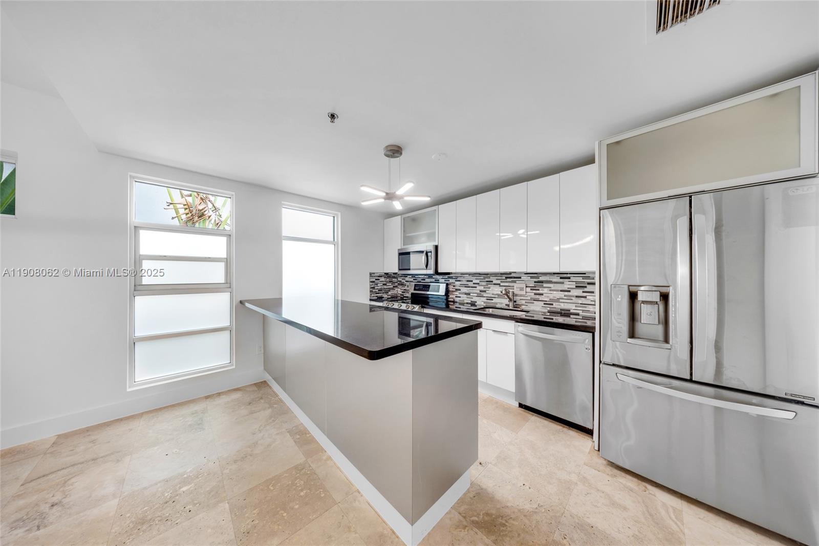 1545 Jefferson Avenue, Unit 103 Miami Beach, FL 33139 - Photo 11 of 35 a kitchen with stainless steel appliances granite countertop a refrigerator and a sink