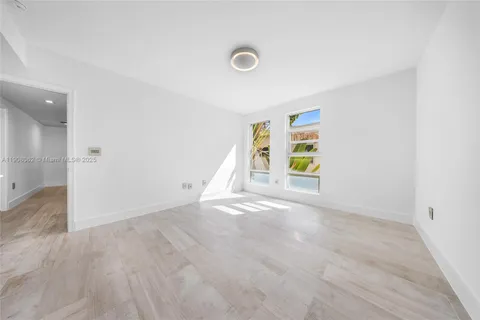 a view of an empty room with wooden floor and closet