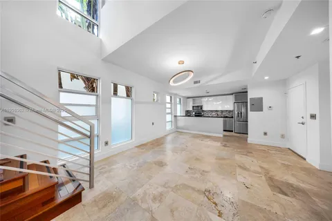 a large white kitchen with stainless steel appliances granite countertop a refrigerator and a stove top oven