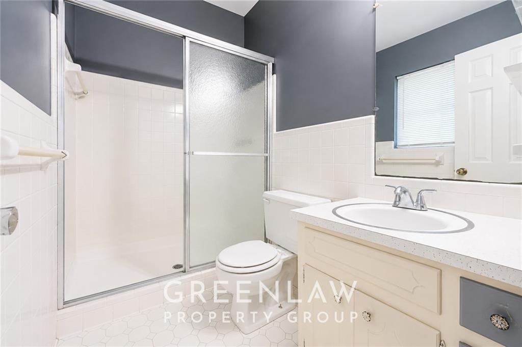 3605 Flat Shoals Road Atlanta, GA 30349 - Photo 29 of 35 a bathroom with a sink a toilet a mirror and shower