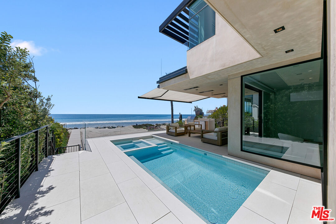 31224 Broad Beach Road Malibu, CA 90265 - Photo 11 of 54 a view of a patio with table and chairs under an umbrella