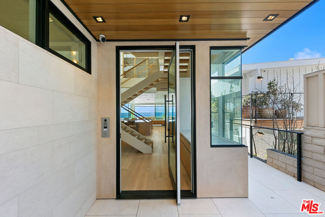 31224 Broad Beach Road Malibu, CA 90265 - Photo 3 of 54 a view of a hallway with dining area and chandelier