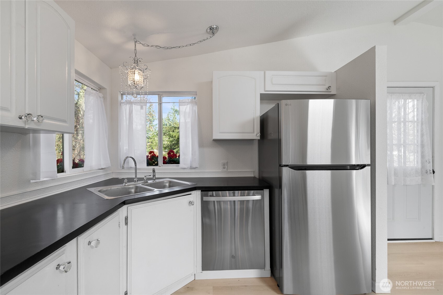 14512 246th Street East Graham, WA 98338 - Photo 13 of 39 a kitchen with a refrigerator a sink and cabinets