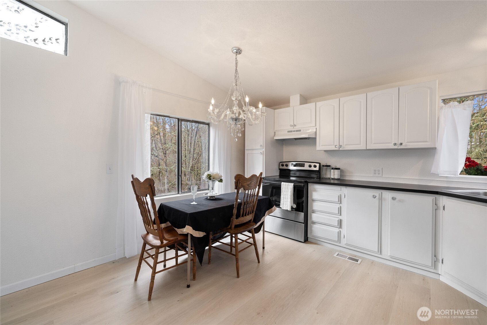 14512 246th Street East Graham, WA 98338 - Photo 10 of 39 a kitchen with granite countertop white cabinets stove and dining table