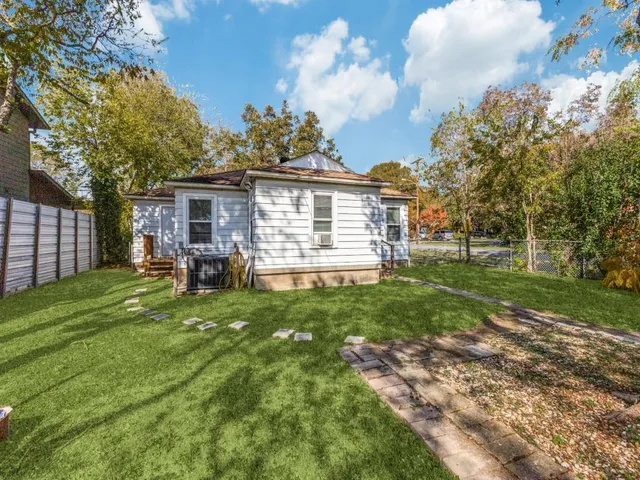 a view of a house with backyard and a tree