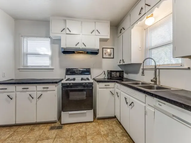 a kitchen with stainless steel appliances granite countertop a sink stove and cabinets