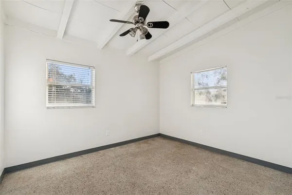 an empty room with a ceiling fan and a window